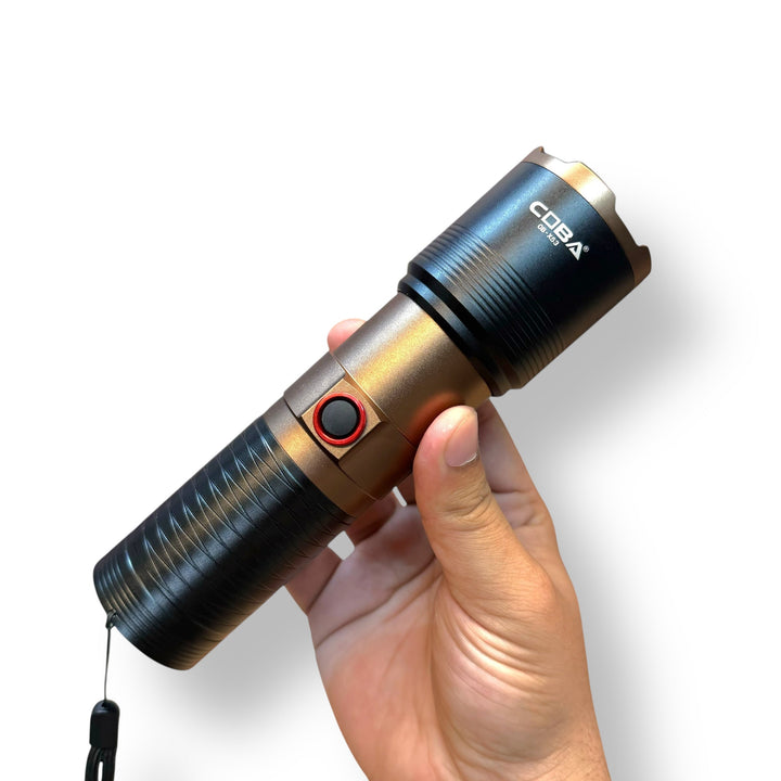 Hand holding a USB charging LED Tactical Flashlight with red power button and wrist strap
