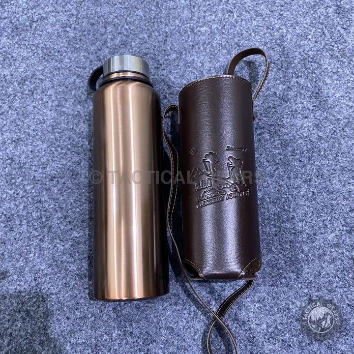 Copper-colored stainless steel vacuum bottle with dark brown leather cover for travel