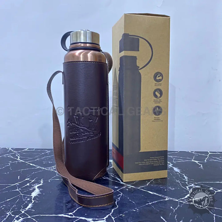 Copper-colored vacuum bottle with leather cover in a tan box and leather carrying case