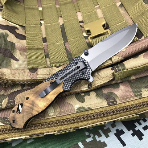 Browning X50 Tactical Folding Knife with silver blade, carbon fiber handle, and wooden grip