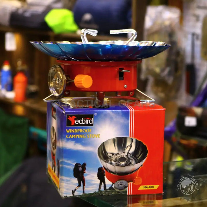 Red Windshield Lotus Camping Stove with blue wind guard and orange control knob