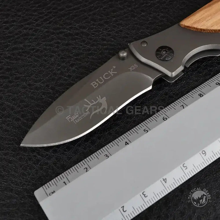 Folding pocket knife with wooden handle and deer emblem on blade Buck Drop-Point X35