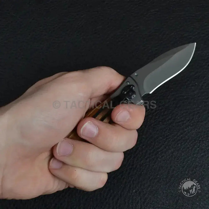 Person’s hand gripping Buck Drop-Point Pocket Knife X35 with dark gray blade