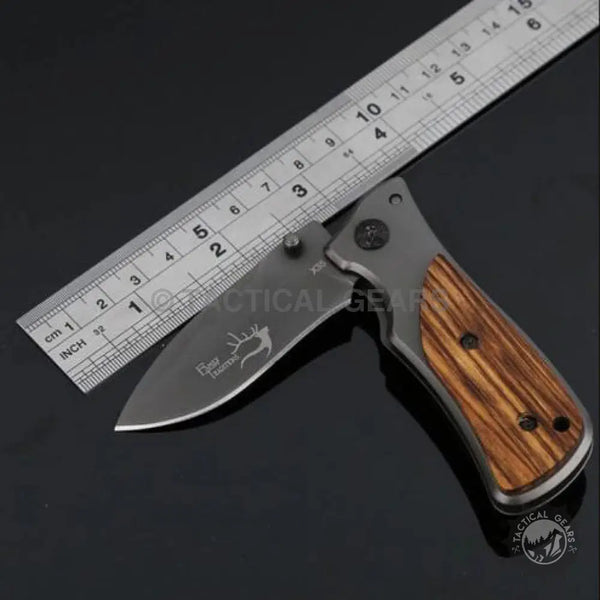 Folding pocket knife with dark blade and wood-grain handle Buck Drop-Point X35