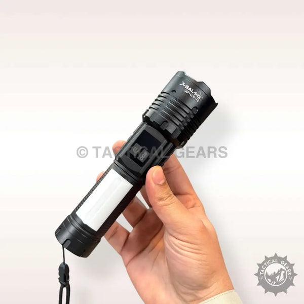 Black X-Balong PM10 USB Flashlight with white side light and wrist strap in hand